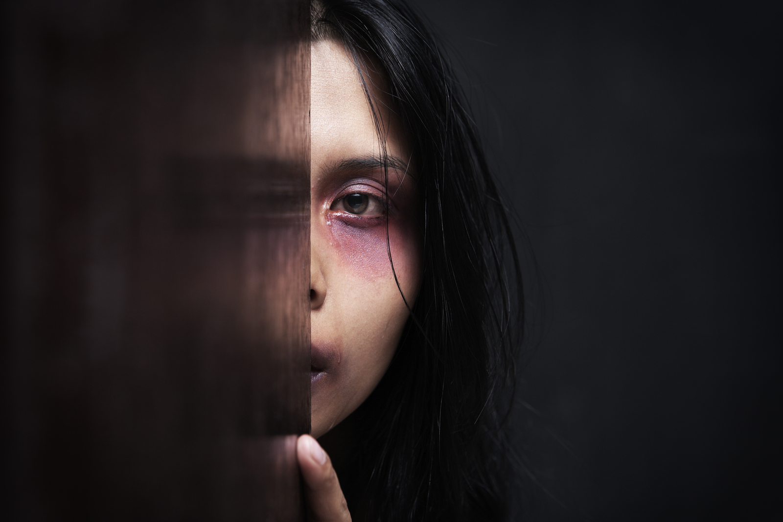 Injured woman hiding in dark concept for domestic violence